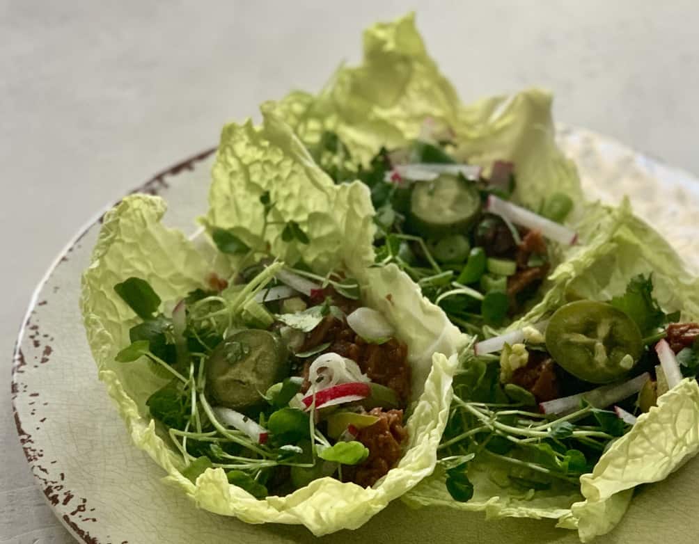 3 Vegan lettuce wraps made with plant based BBQ "pork" topped with watercress, radishes and pickled jalapeños for little extra kick!