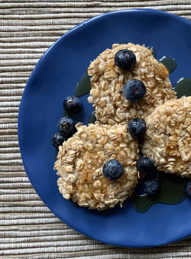 Pan Fried Overnight Oats on a blue plate with blueberries and maple syrup