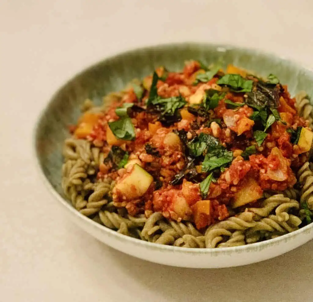 Veggie Tempeh Bolognese over mung bean pasta and topped with fresh basil.
