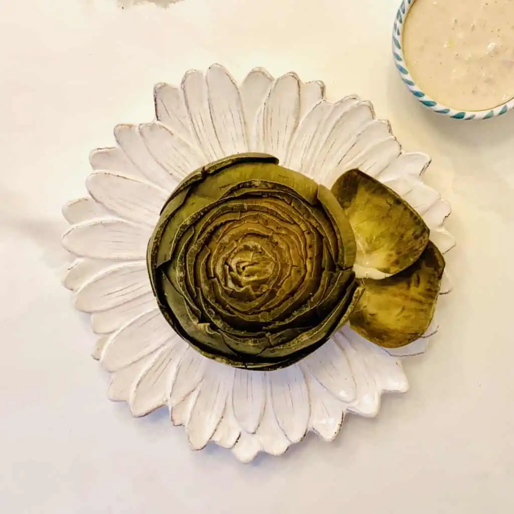 Steamed Artichoke with Yogurt Dipping Sauce on a beautiful white flower plate