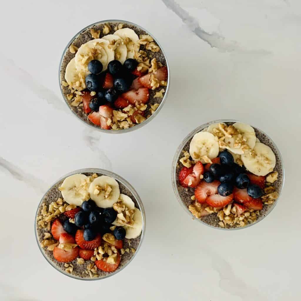 3 Lemon Chia Pudding with Berries, Bananas & Nuts in glass serving bowls
