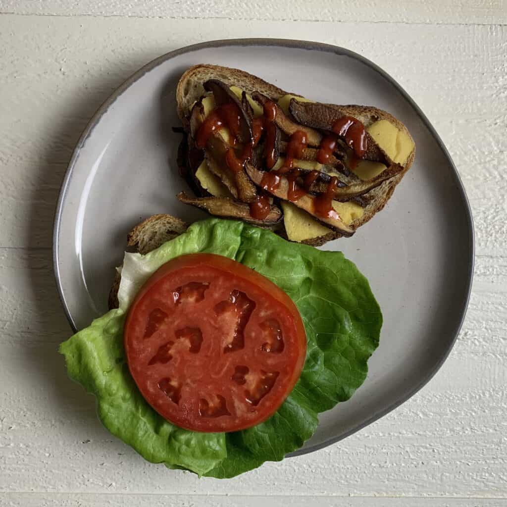 Vegan Shiitake BLT Sandwich with Almond Cheddar Cheese Sandwich open face on plate