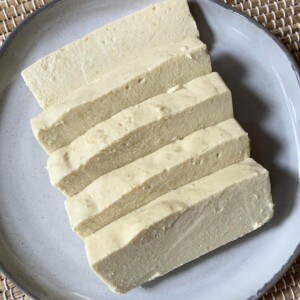 Slices of almond milk cheese on a plate.