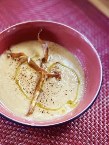 Roasted Parsnip & Cauliflower Soup close-up in a pink bowl with pink placment