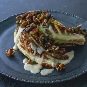 roasted cabbage with tahini dressing and paprika nuts