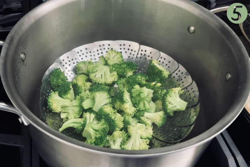 Broccoli florets cooked in a steamer basket.