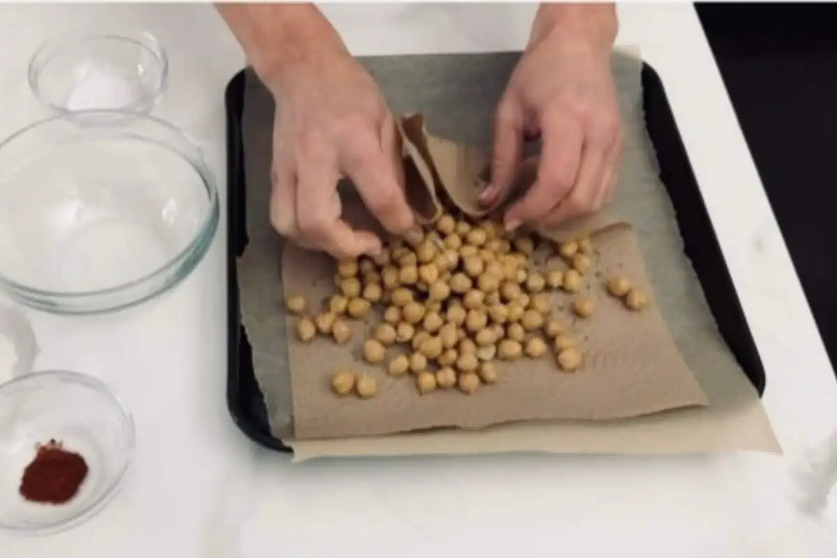 Spreading the chickpeas out on a baking tray.