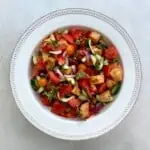 A bowl of gluten-free panzanella salad on the table.
